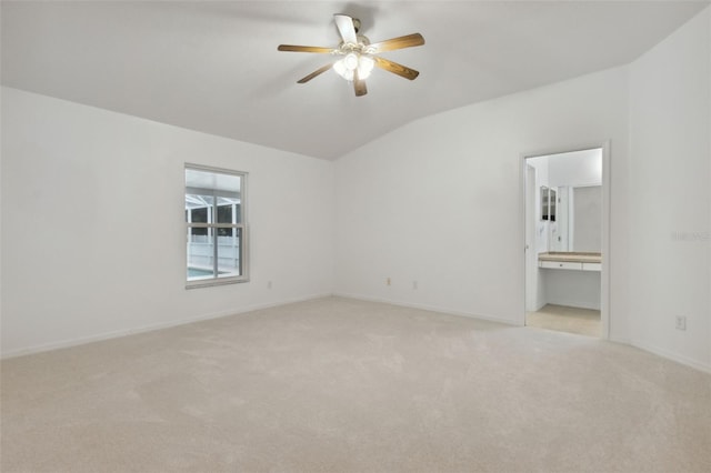 carpeted spare room with ceiling fan and vaulted ceiling