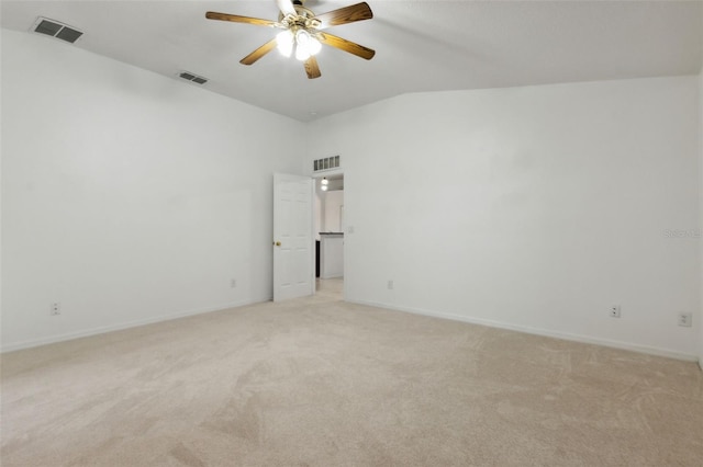 empty room with ceiling fan, light colored carpet, and vaulted ceiling