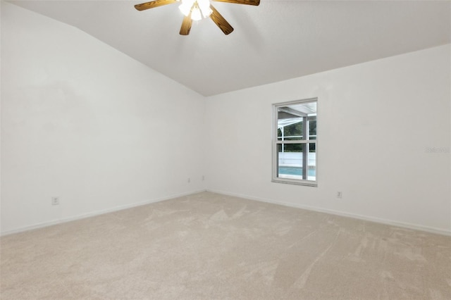 spare room featuring lofted ceiling, light carpet, and ceiling fan