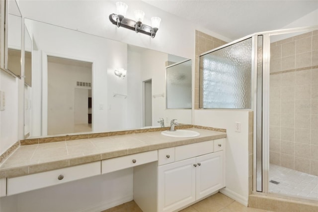 bathroom with an enclosed shower, tile patterned floors, and vanity