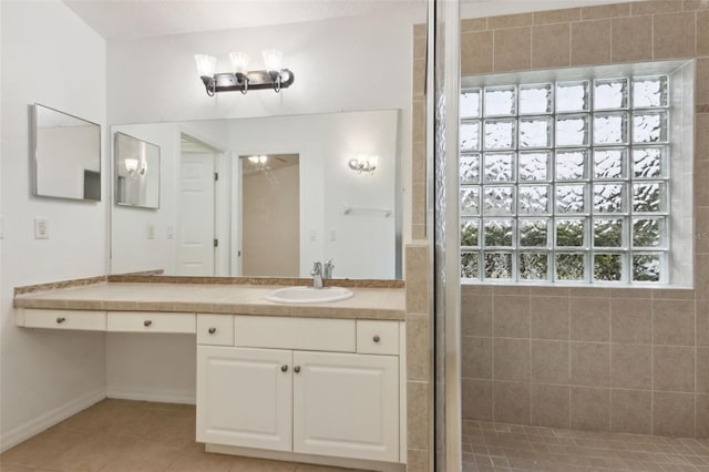 bathroom featuring tile patterned floors, tiled shower, and vanity