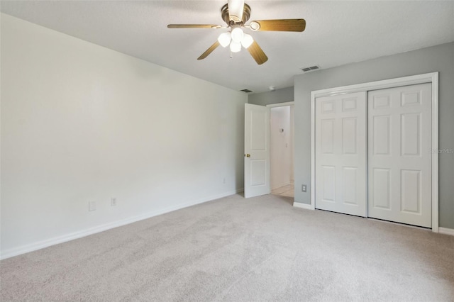 unfurnished bedroom featuring a closet, light carpet, and ceiling fan