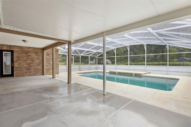 view of swimming pool featuring glass enclosure and a patio