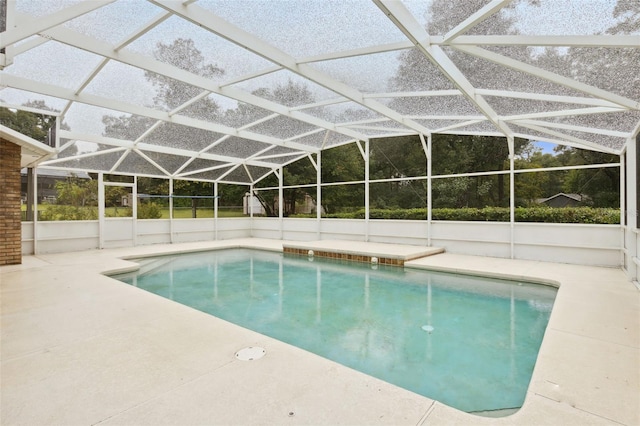 view of swimming pool featuring glass enclosure and a patio area