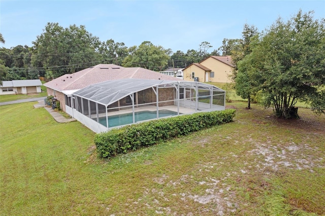 view of swimming pool with a lawn and a lanai