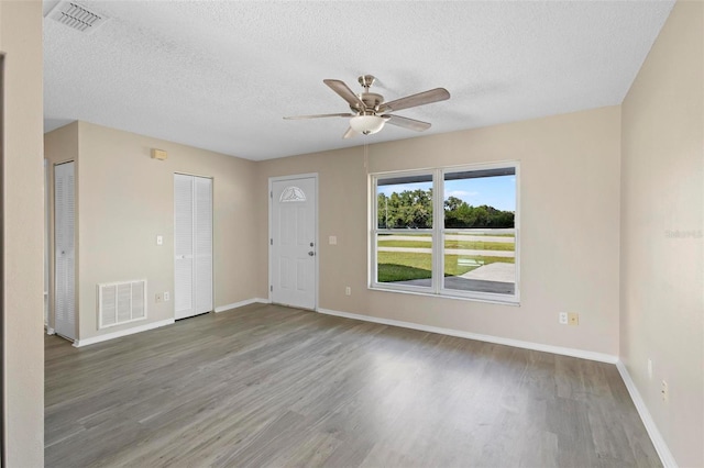 empty room with wood-type flooring, a textured ceiling, and ceiling fan