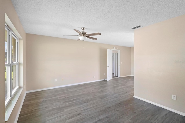 unfurnished room with ceiling fan, dark wood-type flooring, and a textured ceiling