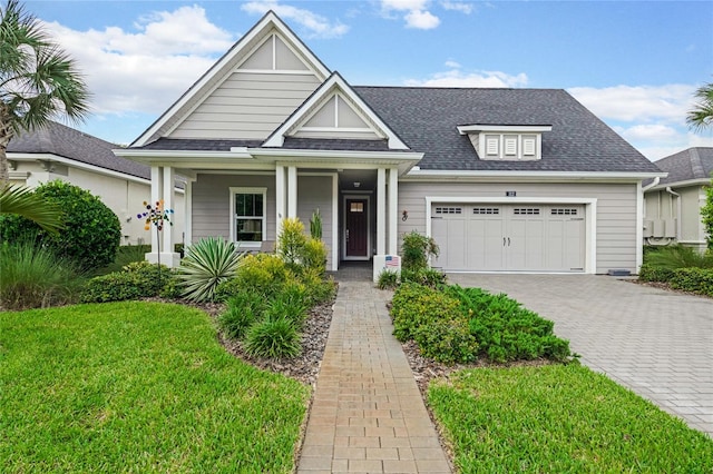 view of front of house with a front yard, a garage, and covered porch