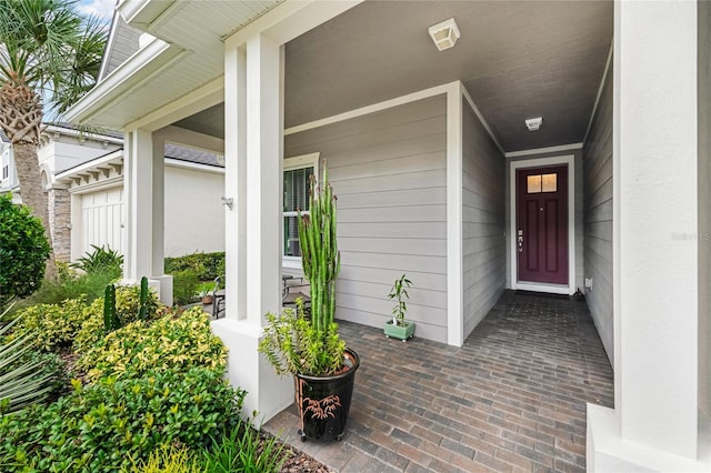 entrance to property featuring a garage and a porch