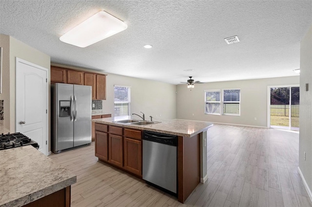 kitchen featuring an island with sink, a healthy amount of sunlight, sink, and stainless steel appliances