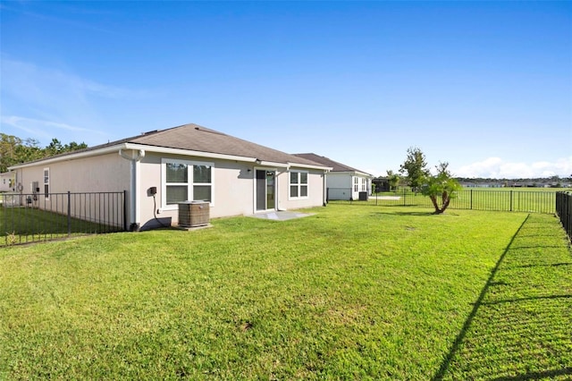 back of house featuring a yard and central AC