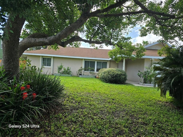 1461 N Felton St, Deltona, FL 32725 - rear view of property featuring stucco siding and a lawn