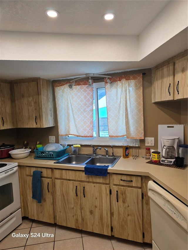 kitchen with sink, white appliances, and light tile patterned floors