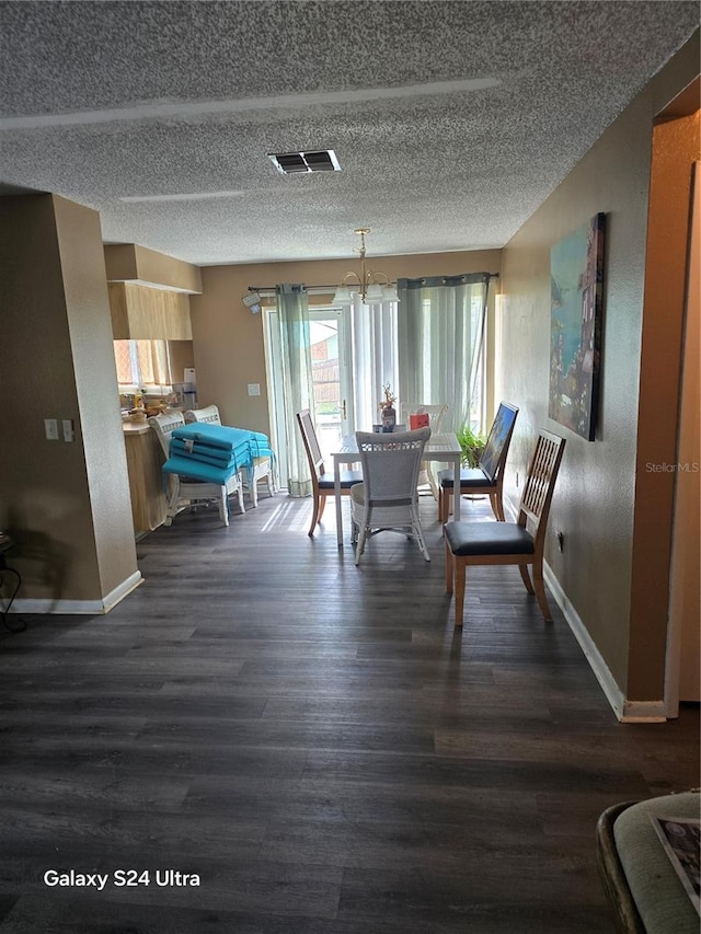 dining room featuring a notable chandelier, dark hardwood / wood-style floors, and a textured ceiling