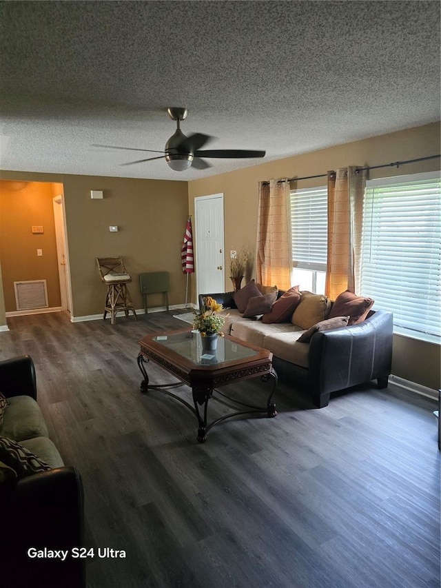 living room with ceiling fan, a textured ceiling, and hardwood / wood-style floors