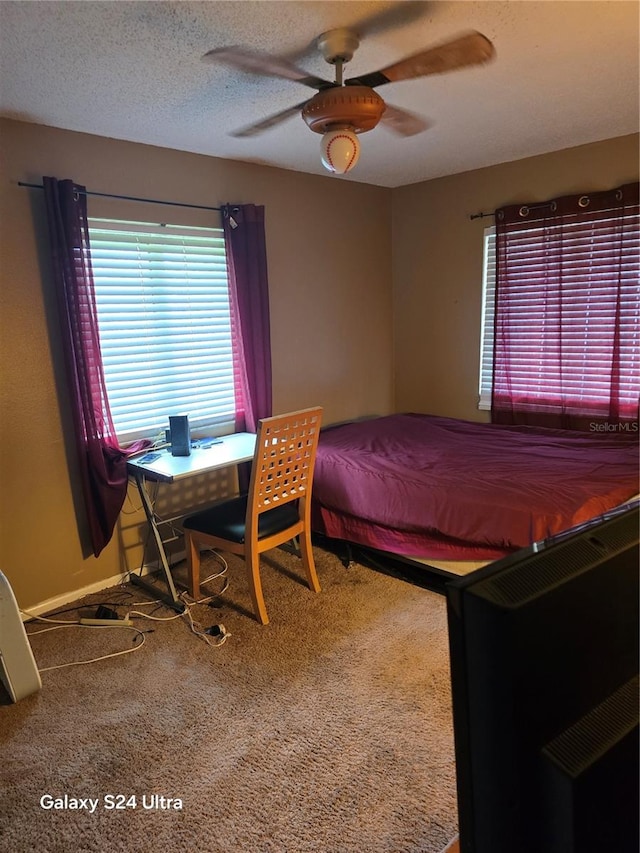 carpeted bedroom featuring a textured ceiling and ceiling fan