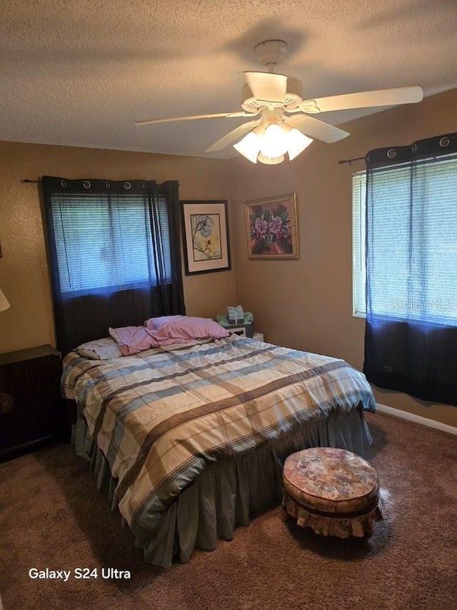 bedroom featuring ceiling fan, carpet, and a textured ceiling