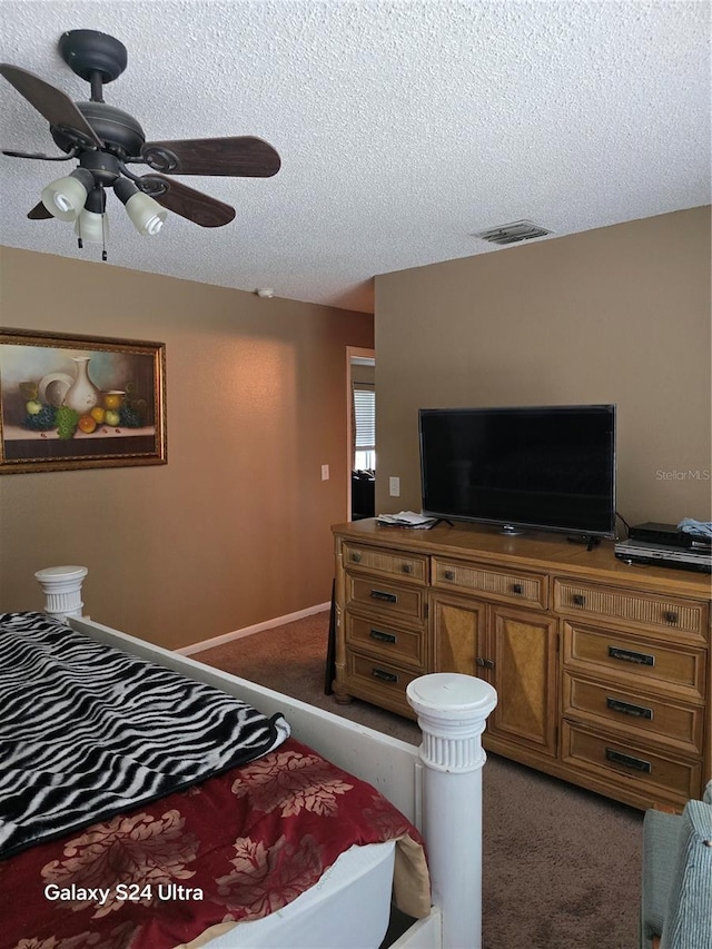 bedroom featuring ceiling fan, a textured ceiling, and dark carpet