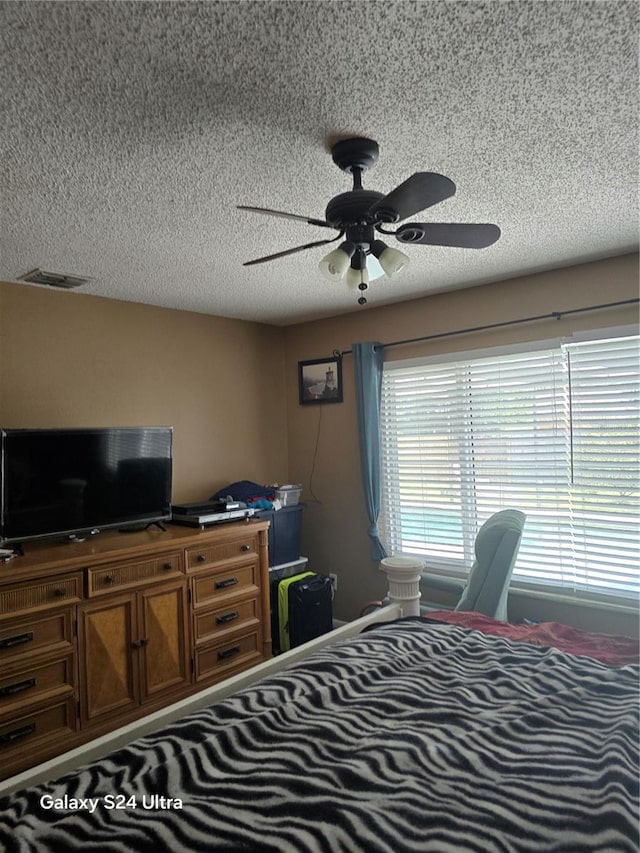 bedroom with a textured ceiling and ceiling fan