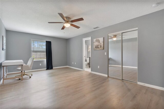 interior space with ceiling fan, a textured ceiling, and light hardwood / wood-style flooring