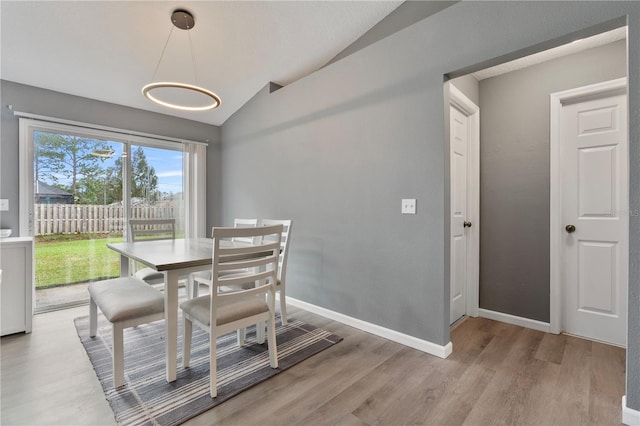 dining area featuring lofted ceiling and hardwood / wood-style floors