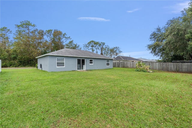 back of property featuring a yard