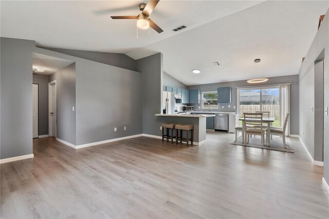 interior space with lofted ceiling, light wood-type flooring, sink, and ceiling fan