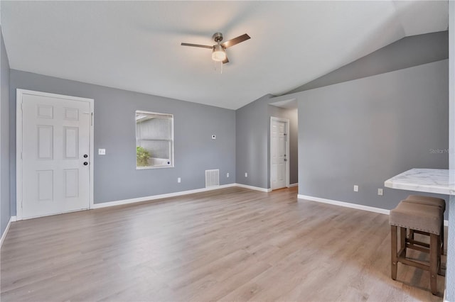 living room featuring vaulted ceiling, ceiling fan, and light wood-type flooring