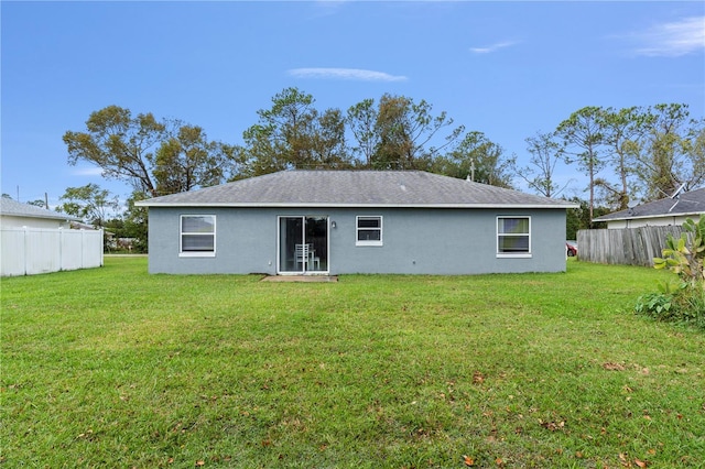 rear view of property featuring a yard