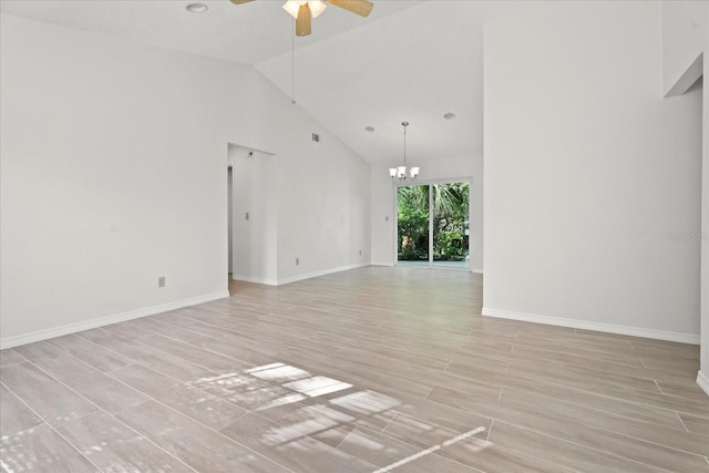 spare room featuring light hardwood / wood-style flooring, a textured ceiling, high vaulted ceiling, and ceiling fan with notable chandelier