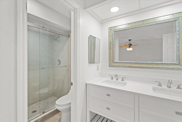 bathroom featuring wood-type flooring, a shower with shower door, toilet, ceiling fan, and vanity