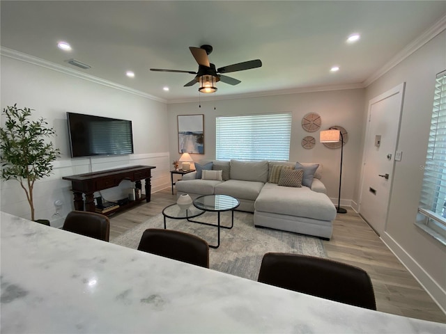 living room featuring ceiling fan, light wood-type flooring, and ornamental molding