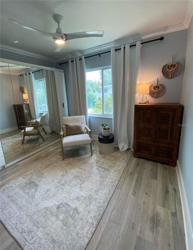 sitting room with ceiling fan, ornamental molding, and light hardwood / wood-style flooring