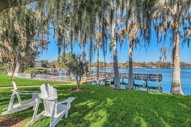 dock area featuring a water view and a lawn