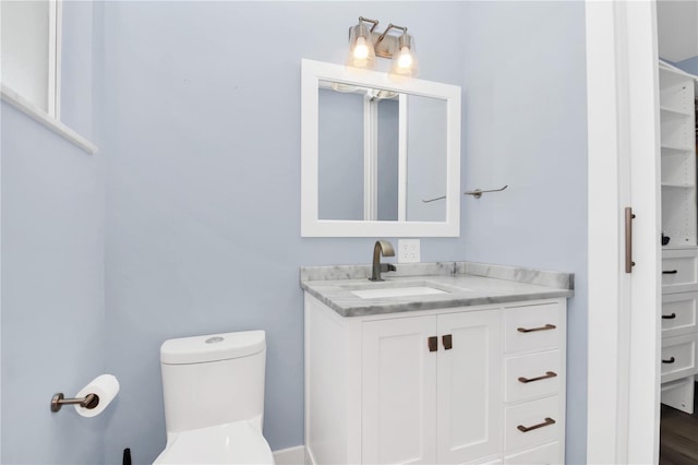 bathroom featuring vanity, hardwood / wood-style flooring, and toilet