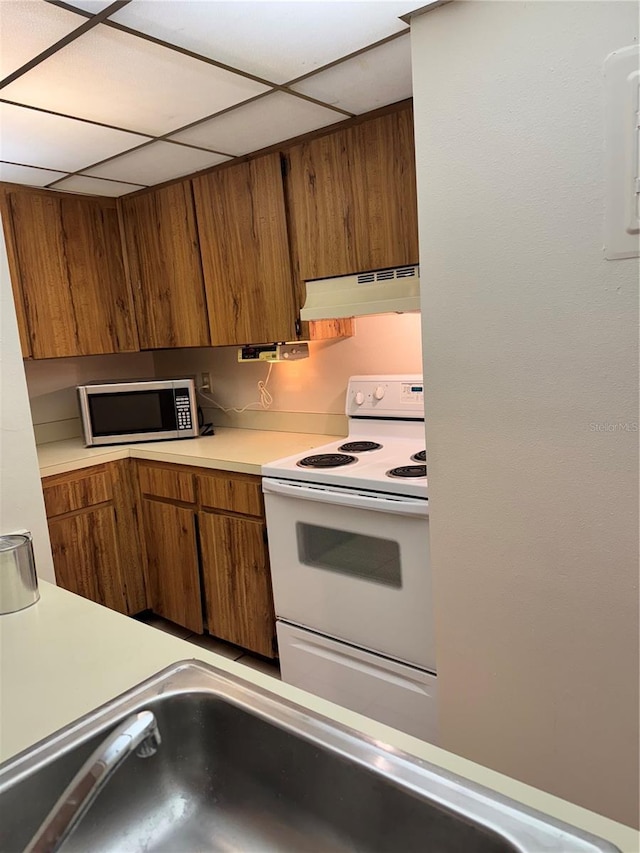 kitchen with sink, electric range, and a paneled ceiling