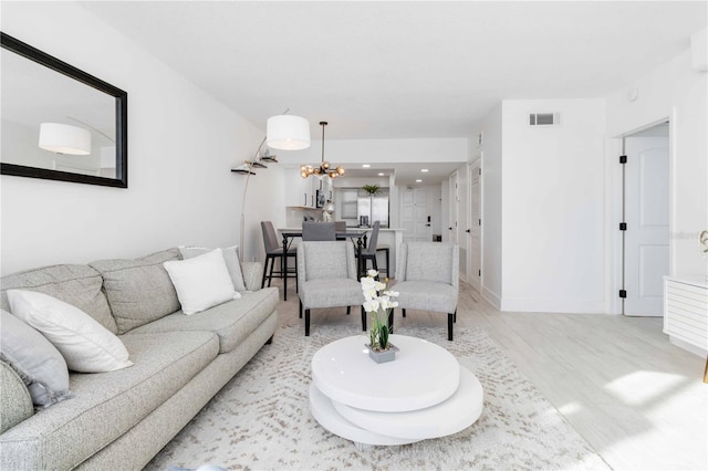 living room with an inviting chandelier and light hardwood / wood-style floors