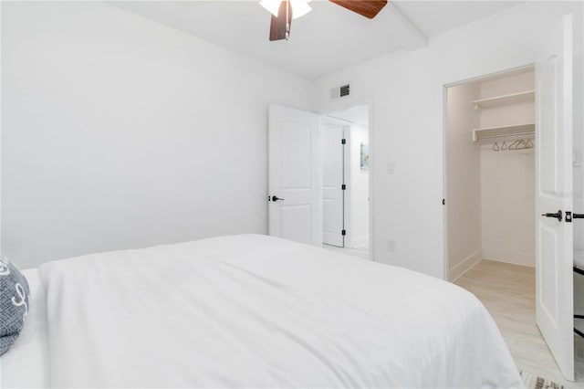 bedroom featuring light hardwood / wood-style floors, a closet, a spacious closet, and ceiling fan