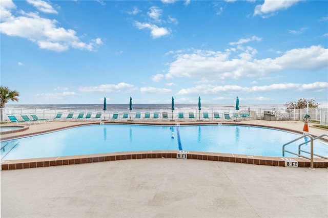 view of swimming pool featuring a patio and a water view