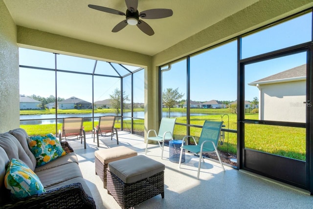 sunroom / solarium with a water view and ceiling fan