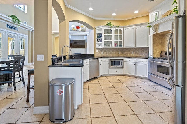 kitchen featuring appliances with stainless steel finishes, sink, backsplash, white cabinets, and ornamental molding