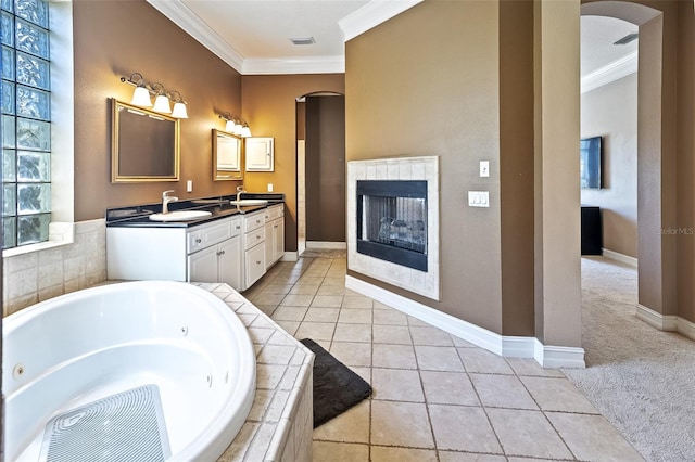 bathroom with vanity, ornamental molding, tile patterned floors, and tiled bath