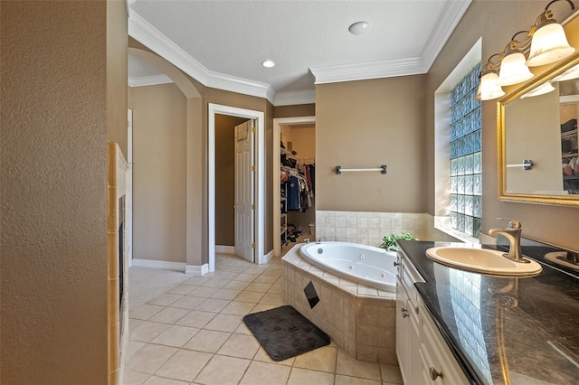 bathroom with vanity, ornamental molding, a relaxing tiled tub, and tile patterned floors