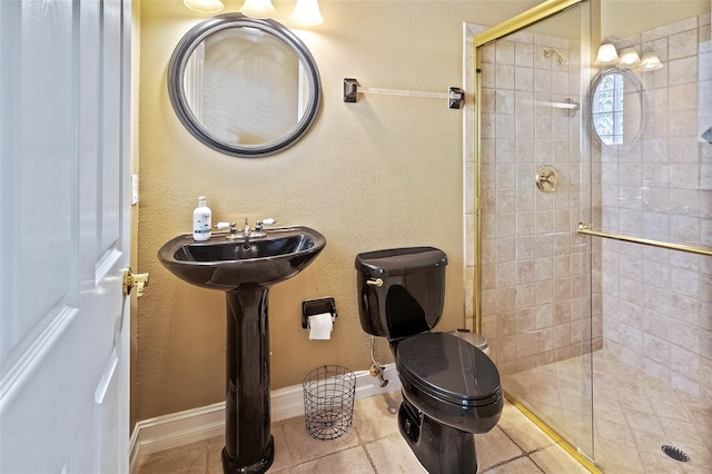 bathroom featuring tile patterned floors, a shower with shower door, and toilet