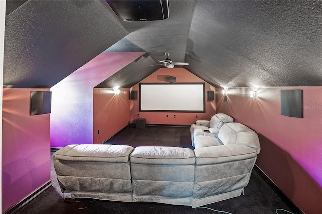 home theater with vaulted ceiling, dark colored carpet, a textured ceiling, and ceiling fan