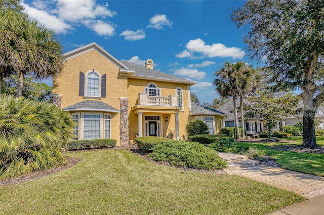 view of front of property with a balcony and a front yard