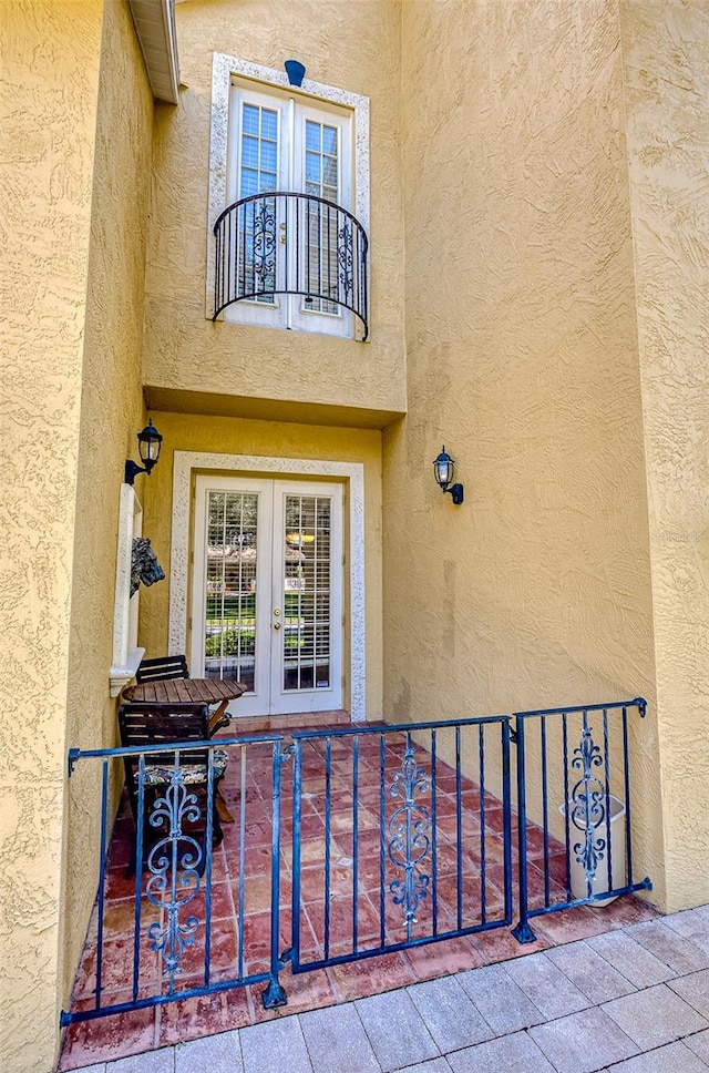 doorway to property with a balcony and french doors