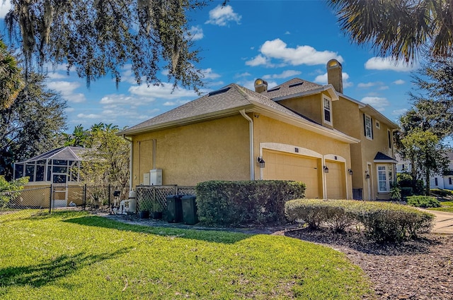 view of side of property with a yard and a garage