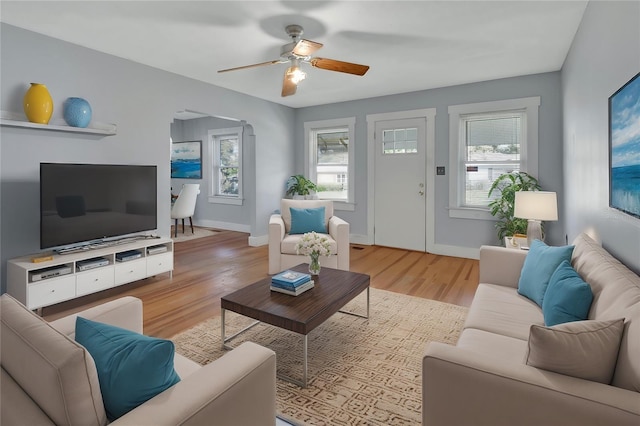 living room featuring light hardwood / wood-style floors, a healthy amount of sunlight, and ceiling fan