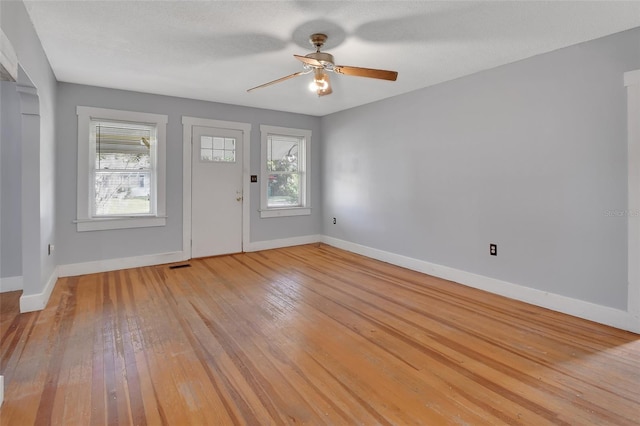 entryway with a textured ceiling, light wood-type flooring, and ceiling fan